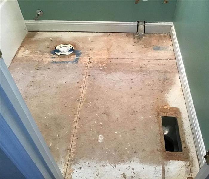 water damaged bathroom with tile removed revealing soaked subfloors