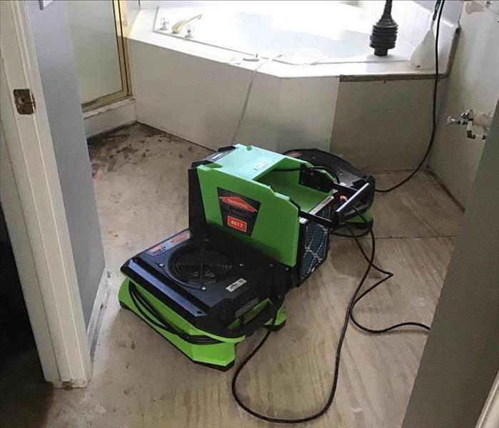 Water damaged master bathroom with drying equipment set up