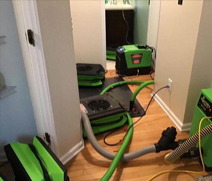 water damaged flooring with air movers set up to dry the affected area