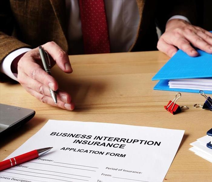 Agent offers business interruption insurance application documents.